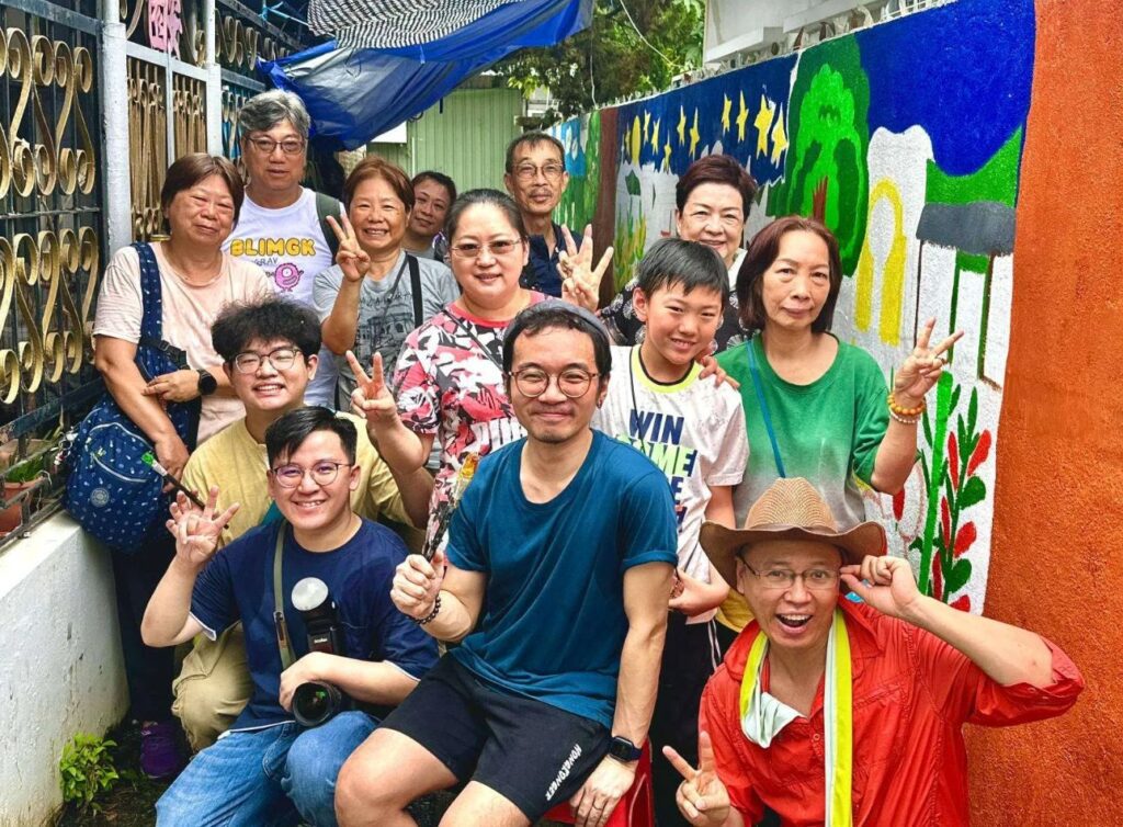 在洪水橋的土地上,有一個快將消失的村落——亦園村。這裡不是旅遊景點,也不是歷史遺跡,而是數代人曾經真實生活的地方。麥爵閎(人稱麥導),以導賞及壁畫記錄村落故事,成了這片土地最後的見證者。他說的話,不花俏,卻句句有力,因為每一段記憶都是一個人、一隻動物,一個家庭的真實。