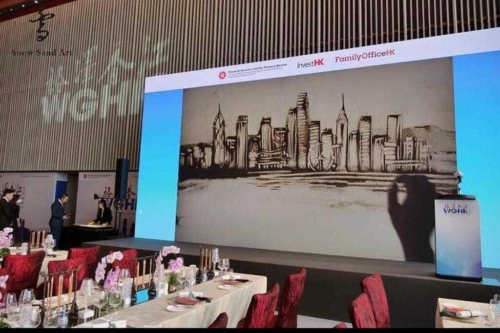 在香港的藝術界,鍾雪是一位別具一格的創作者。她不是用畫筆,而是用沙子,把一個又一個動人的故事呈現在觀眾眼前。從2015年開始,她不只是一位沙畫藝術家,更是一位推動者,她成立了香港沙畫協會、創辦全球首個沙畫體驗館,並領導全港第一個分級考核沙畫證書學院。這一切的起點,源於她對故事的熱愛和對沙畫無限可能的堅信。