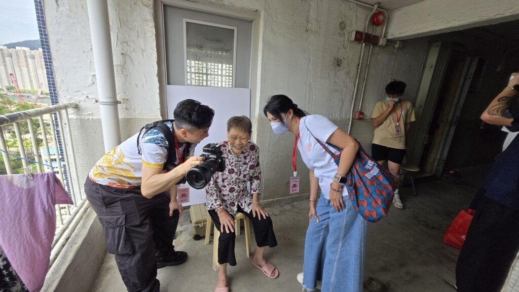 在香港,人口老化問題日益嚴峻。根據統計,65歲或以上的長者人口已接近全港總人口的四分之一。這不是一串冰冷的數字,而是無數正在默默生活的長者,他們可能獨居、生活簡單,甚至多年來從未為自己留下過一張正式的照片。正是在這樣的背景下,「港澳愛傳承商龍會」發起了一項充滿人情味的慈善行動——「老友快途美」,由專業攝影師與義工組成團隊,走入屋邨與護老院,為長者免費拍攝個人照,記錄他們最真摯的笑容與生活的痕跡。