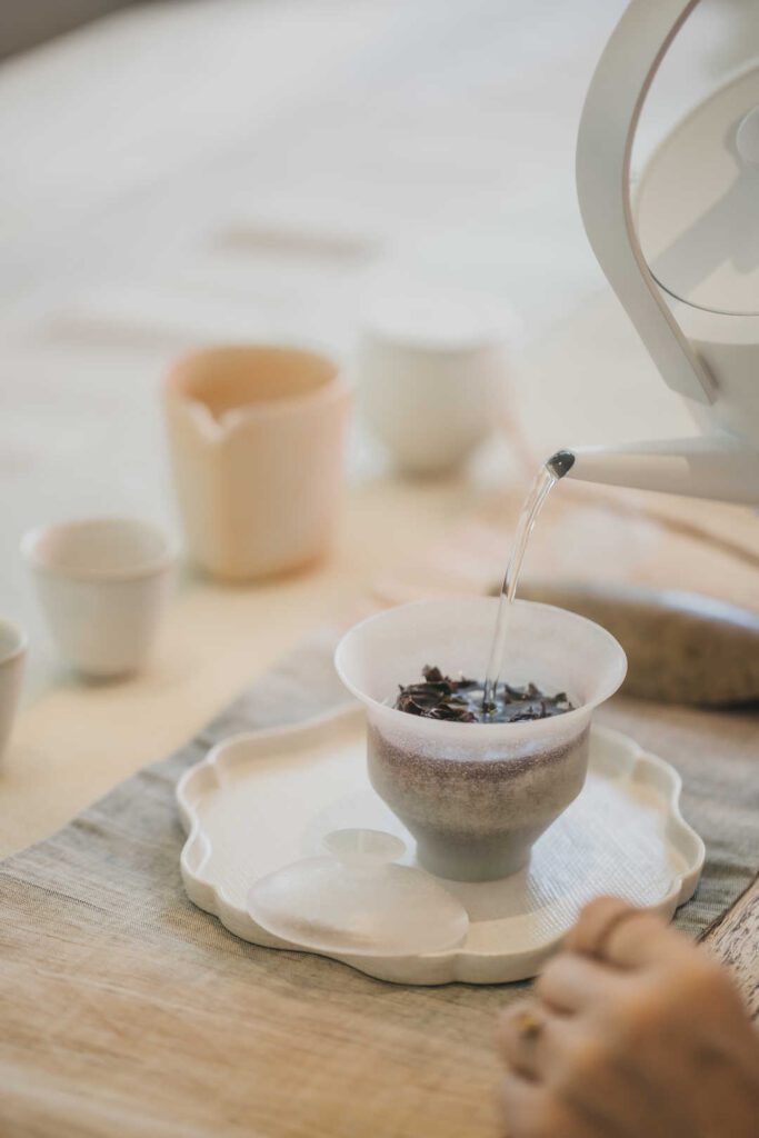 在這個越來越快的世界裡，越來越多人想要慢下來，尋找一種能讓心靈靜定的方式。茶，這項古老的文化載體，在現代人的生活中，重新被賦予了意義。它不只是飲品，更是一種生活態度，一種與自己對話的方式。關琬潼小姐Shadow，就是這樣一位在茶的世界裡找到內在節奏的人。她從小與茶結緣，經過多年探索與沉澱，最終選擇進一步走進由莊洪錦雅老師主導的大益茶道課程。透過她的學習歷程，我們看見了茶的深度，也看見了人與文化之間動人的連結。