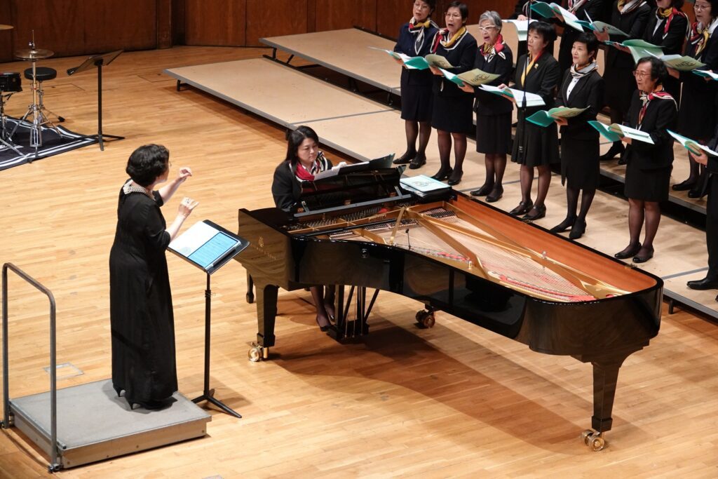 在香港，有一群校長組成的合唱團，唱的不是流行曲，也非傳統聖詩，而是一首首蘊藏中國文化底蘊的古詩詞。在這個看似忙碌且嚴肅的身份背後，卻藏著對教育、音樂與文化傳承的深厚情感。而這一切的推動者之一，就是高舒——香港校長合唱團的指揮與編曲者。