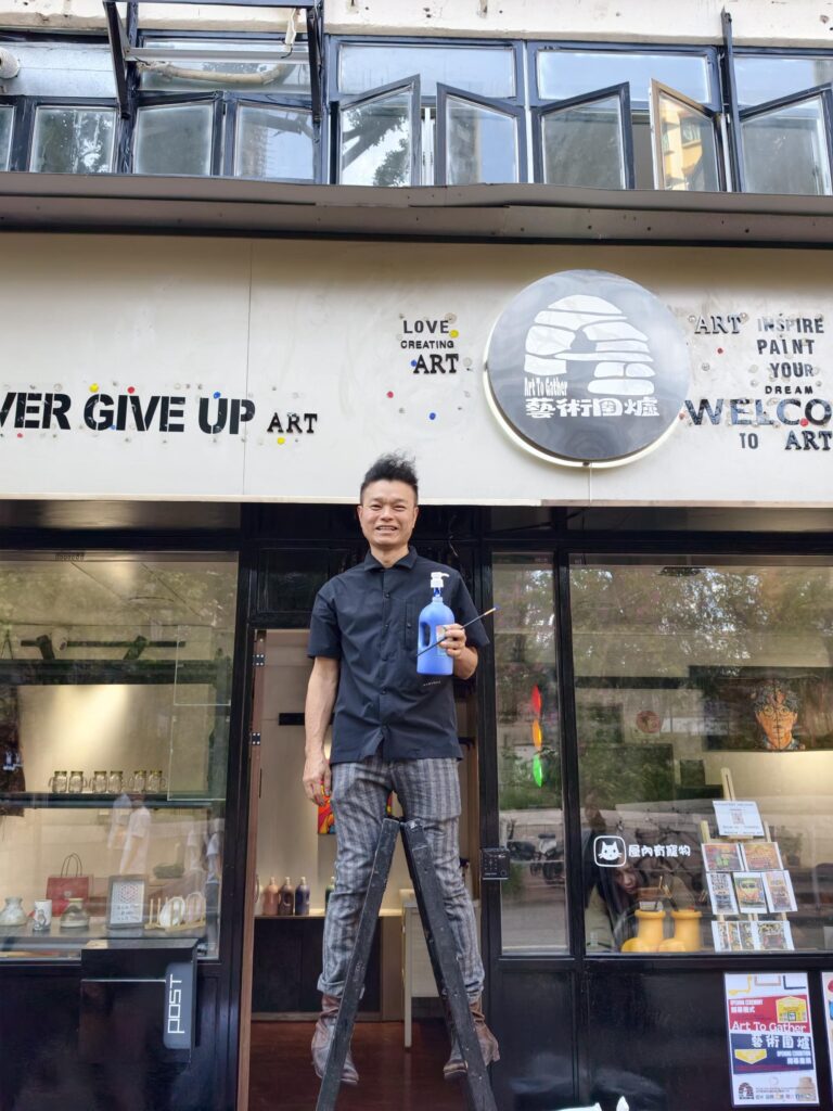 走進位於街角的一間地舖，第一眼看去或許不覺得特別寬敞，但吳運忠Eric笑著指出，這個空間其實有兩層，樓底也非常高。他說，正是這種結構讓他第一眼就愛上了這個地方。這裡並非傳統的藝術空間，而是一個充滿可能性的「藝術圍爐」，不僅能讓藝術發生，更希望讓人聚在一起、互相取暖。