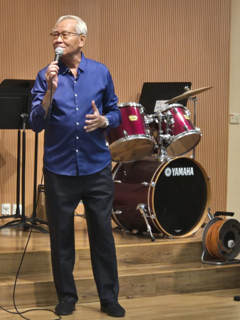 採訪那天，何應占先生（何sir）說話不花巧，句子也不急。他更像一位見慣風浪的前輩，把人生一段段攤開來講：從少年時的艱難自立，到警隊三十年的紀律與磨練，再到退休後仍在法律圈裡忙碌，最後把更多時間投向社區、合唱團與義工服務。聽他慢慢說，你會明白他不是在講「成功學」，而是在講一個人怎樣守住原則，也守住對人的溫度。