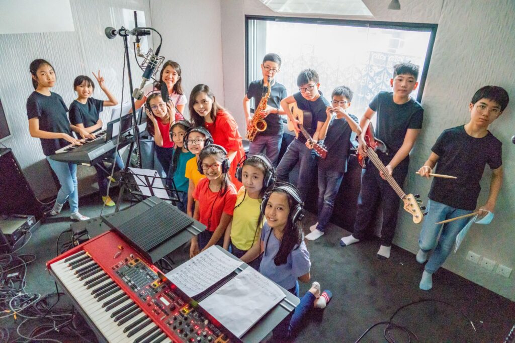 一個原本不敢上台的學生，最後在眾人面前透過打鼓完成一首曲，台下掌聲響起，那一刻他記住的可能不是節拍，而是「原來我都可以」。蘇詠思校長最在意的，就是把這種改變一次次變成可能。她把對文字與旋律的敏感，從填詞延伸到作曲，從同儕分享進取到舉辦個人音樂會，從小型創作演化到影像作品。回到校園場景，讓學生不只唱歌，更用自己的樂器參與、合作、完成一場又一場真正的演出。這篇文章要寫的，是她如何將多年創作經驗揉進教育舞台，編寫學生的樂譜，也把正向與盼望，寫進他們的日常。