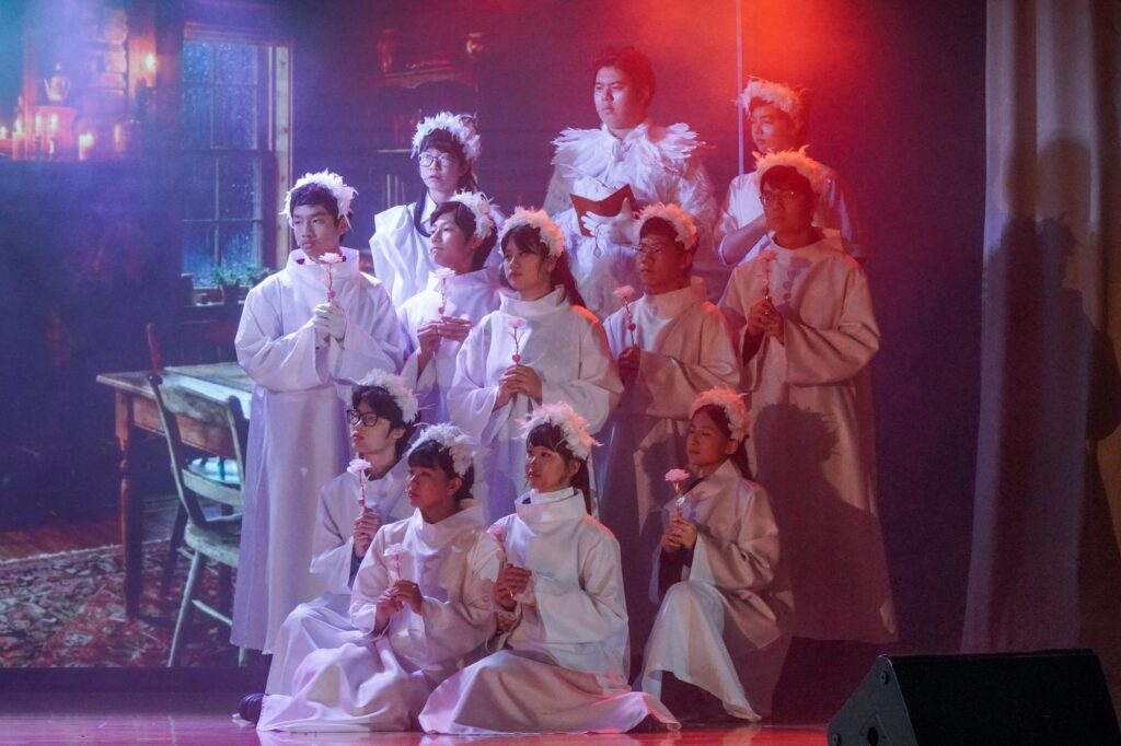 不是每一種學習都能在課室裡完成。有些能力，包括：自信、合作、承擔、面對壓力時的穩定，都需要一個更真實的場景，一群人為同一件事努力，彼此補位，然後在燈光亮起的一刻，把成果交給觀眾。鐘聲慈善社胡陳金枝中學多年來把音樂劇當作校園文化的一部分，並非為了「做一場表演」，而是刻意為學生創造一種獨特的成功感：讓他們在台前台後都能找到位置，感受到自己被需要、能做到、做得到。音樂劇也因此成為一種活動式學習——把語言、情感、價值觀與團隊精神，放進同一個具體而熱烈的練習場。