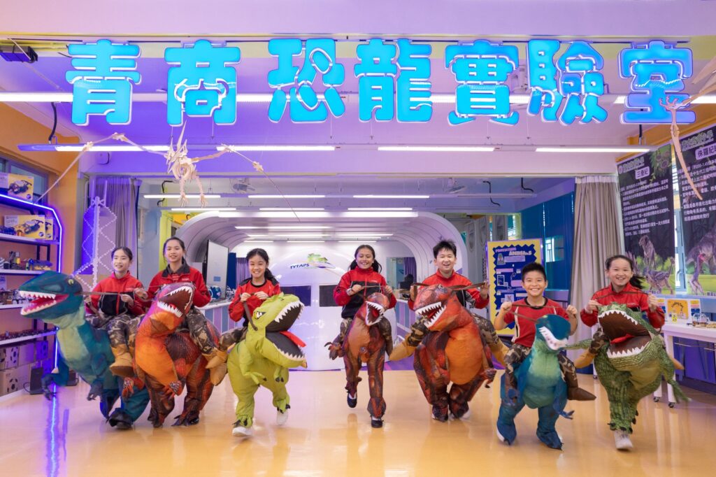 走進青衣商會小學,第一個迎面而來的「打卡點」不是壁報板,也不是操場,而是一隻高達七米的「恐龍」吉祥物「龍大樑」。它不是真恐龍,卻像校園的一份子,天天站在門外迎接孩子。麥美茵校長說,學生只要看見「龍大樑」,腦海就會浮現校園的歡樂與學習的趣味;更重要的是,它象徵「國之棟樑」,每個孩子都值得被好好栽培、被看見、被成就。這份「看見」,並不止於口號,而是一所學校如何把理念落在日常每一個細節之中。