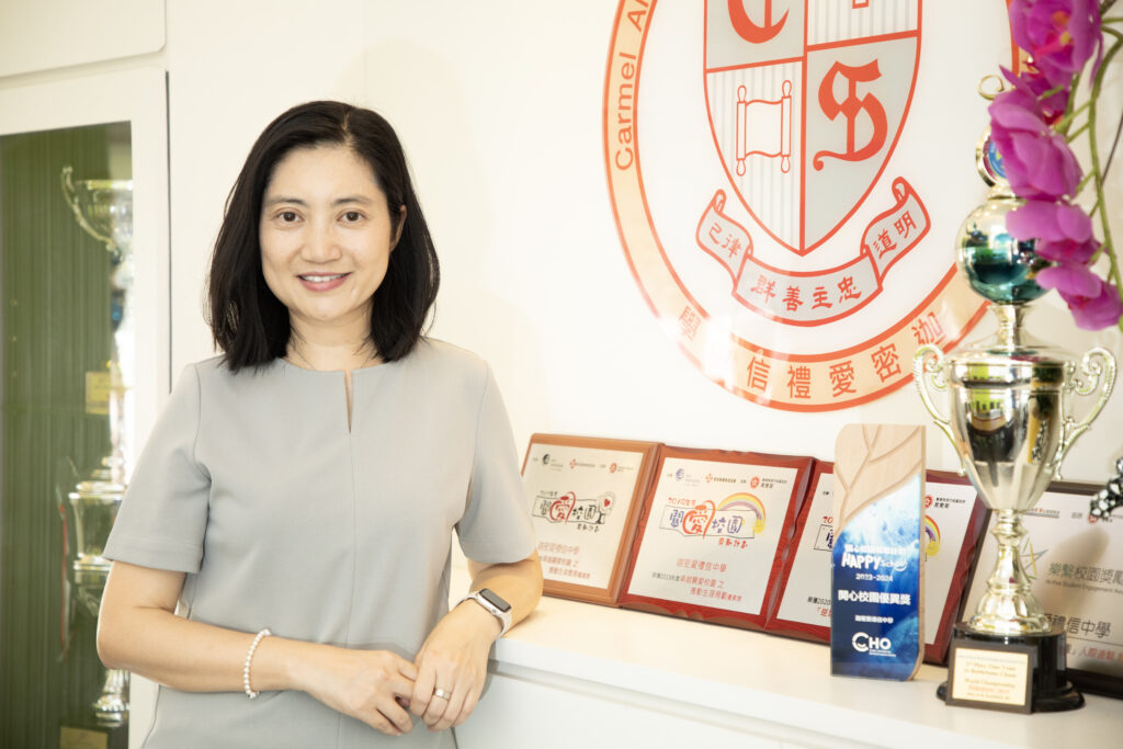 在升學與排名被看得很重的今天，教育話題往往離不開「Banding、英中、成績走勢」。但在一次對談裡，迦密愛禮信中學黃敬珊校長把焦點悄悄移開，她談的不是哪一批學生更「勁」，而是哪一個孩子曾被相信，因而敢再向前一步。她不強調大道理，只講她看見的：教育若只剩分數，孩子或許只是合格；但若有人願意陪他建立生命，他才會真正發光發亮。這篇專訪，帶你走進她的教育世界：從「Banding不是最緊要」到「安全網」的意義，從運動與活動如何磨出品格，到師生之間那種真誠的同行，原來最能改變人的，從來不是標籤，而是一份長久的信任。