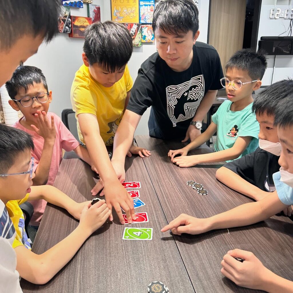 在香港,補習往往被視為「追成績」的必經之路;但當功課、測驗與比較成為日常,愈來愈多孩子開始抗拒學習,甚至把自己定義為「我唔得」。N+ 教育中心創辦人 蔡德偉(Nic Sir)正是從這些現場感受出發的人。他出身社工,曾入校擔任駐校社工,近距離看過孩子如何在壓力下失去自信,也看過家庭與學校之間的落差如何把孩子推向逃避。2012 年,他創立自己的教育中心,嘗試用另一種方式做教育:不只補知識,更重視孩子的情緒、態度與學習動機,讓他們重新願意學、學得起、也學得下去。