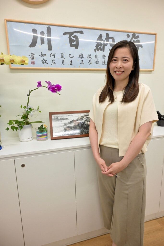 談起職涯起點,世界龍岡學校劉皇發中學 陳慧韵校長 說得很坦白:她最初並不是立志要做校長。她想走進教育,只因一路走來遇過很多「恩師」,在她成長的路上拉過她一把,讓她相信教育不是一句口號,而是能改變人生的力量。她形容自己出身並不寬裕,讀書也不是那種「樣樣全能」的尖子。大學時期她先讀的是商科,畢業後也曾進入銀行做MT(Management Trainee)。那份工作得來不易,但她做了幾個月便決定離開。原因不是能力問題,而是她發現自己在那套生活與話題中「格格不入」:日常圍繞股價升跌、茶餘飯後談資產配置增值等,跟她想要的很不同。
