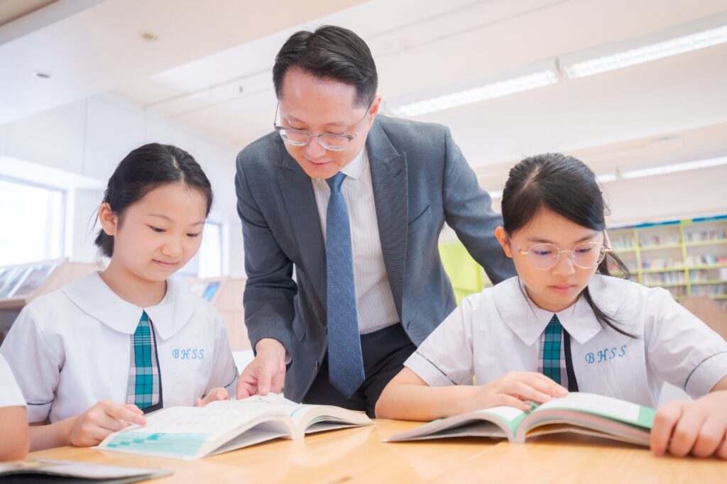 如果你以為推動AI教育的人,一定是從小立志、一路直線前進的「科技天才」,香港聖公會何明華會督中學 金偉明校長的故事會讓你改觀。他的起點並不是宏大的志願,而是一份單純的好奇心:想弄清楚世界如何運作、學習如何更有效。從大學修讀電腦科學,到踏入職場成為程式員;從嘗試過便利店、茶餐廳、搬貨、貿易等不同工作,到最後決定當上老師,他走的是一條不斷探索、把經驗轉化為教育養分的路。今天他談AI,談的不是追逐潮流,而是更貼近家長與教育界共同的焦慮與期待,在變化快得讓人追不上時,學校如何既讓學生掌握新科技,也守住價值觀與軟技能,讓孩子不只「學得多」,更能「走得遠」。