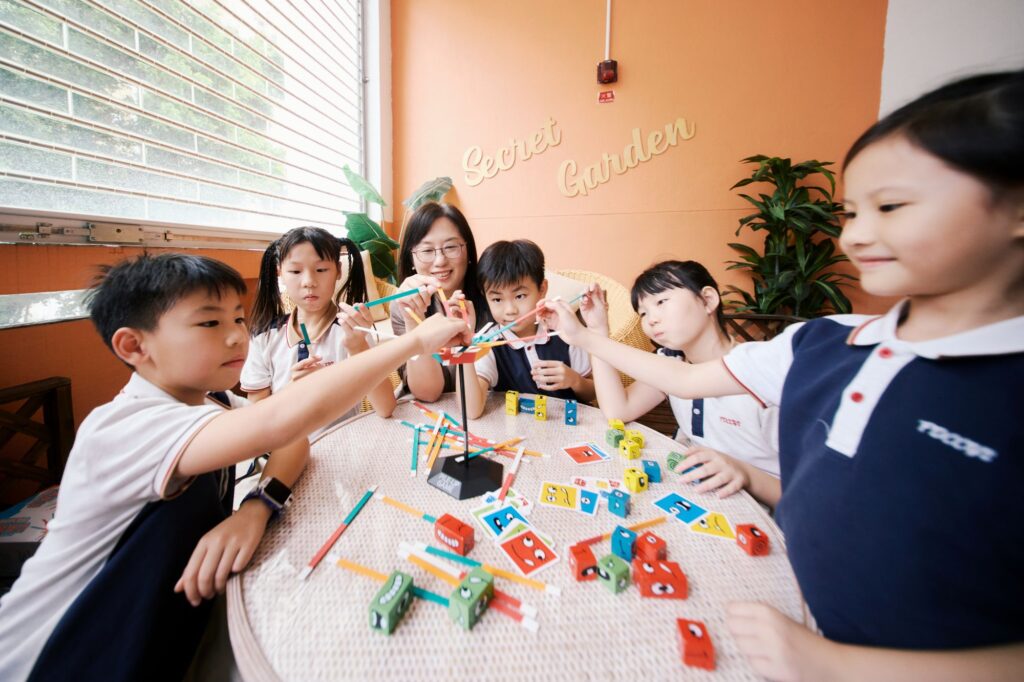陳寧欣校長在五邑鄒振猷學校工作了三十年。回望入行之初,她坦言自己並不是一開始便立志成為老師。大學讀的是社會學,畢業後找工作,見到有小學聘請老師,便抱着「不如試下」的心態投身教育。這份工作最初來得有點偶然,卻在日復日的教學中慢慢變得重要。她從不把教育說成一句漂亮口號,而是很坦白地說,自己也是在課室裡一邊做、一邊學、一邊修正。剛開始教書時,她沒有太多經驗,也曾面對高年級學生時感到壓力;但她性格正面,遇到困難便繼續嘗試。那些初入行的跌碰,反而讓她更明白教師需要謙卑,也需要不斷成長。