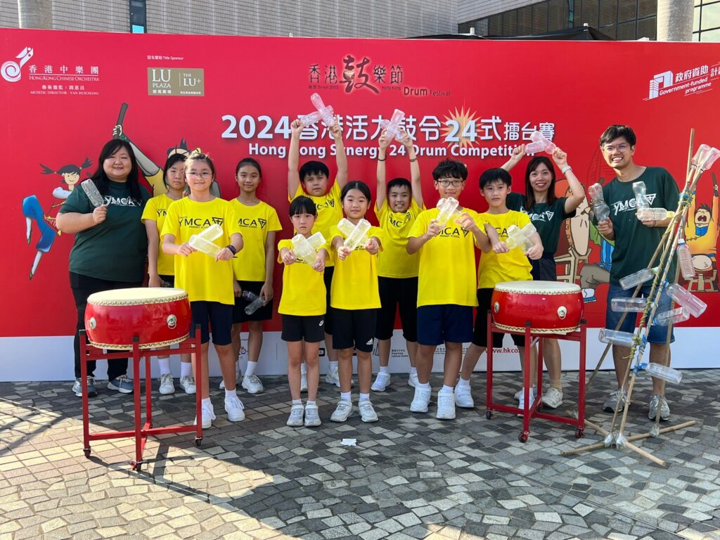 潘志煒老師仍記得,第一次帶學生走進社區做環保音樂活動時,場面其實不算完美。孩子們要自己準備、自己佈置、自己向陌生人介紹理念,還要即場用自製樂器表演。沒有成熟的說辭,沒有大人的全程代勞,甚至一開始也不是人人相信他們能做到。可是,正因為這一切都由孩子親手完成,現場反而有一種難得的真誠。從區議員的辦事處,到環保機構、電台節目和傳媒訪問,這班小學生一步一步證明:只要大人願意聆聽,孩子的聲音,也可以走進社區。
