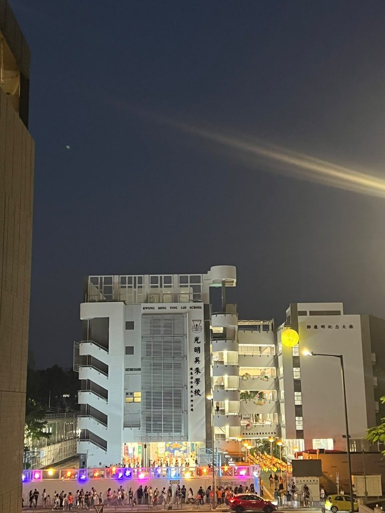 光明英來學校一年一度的「中秋聯歡晚會」,除了是單純的節日慶祝,更成為全校師生、家長、校友甚至整個元朗社區人士的年度聚會。每年此時,數以千計的「英來人」從四方八面匯聚於元朗元政路十二號的光明英來學校校園,在笑語聲中共享天倫,同時見證學校不斷向前邁進的活力。本年度的中秋晚會,雖沒有去年二十周年校慶的隆重啟動禮,卻依然承載著同樣深厚的意義——它是一份對傳統的堅守,一股凝聚人心的力量,更是一個讓所有持份者感受校園溫馨的氛圍,加強歸屬感的珍貴契機。