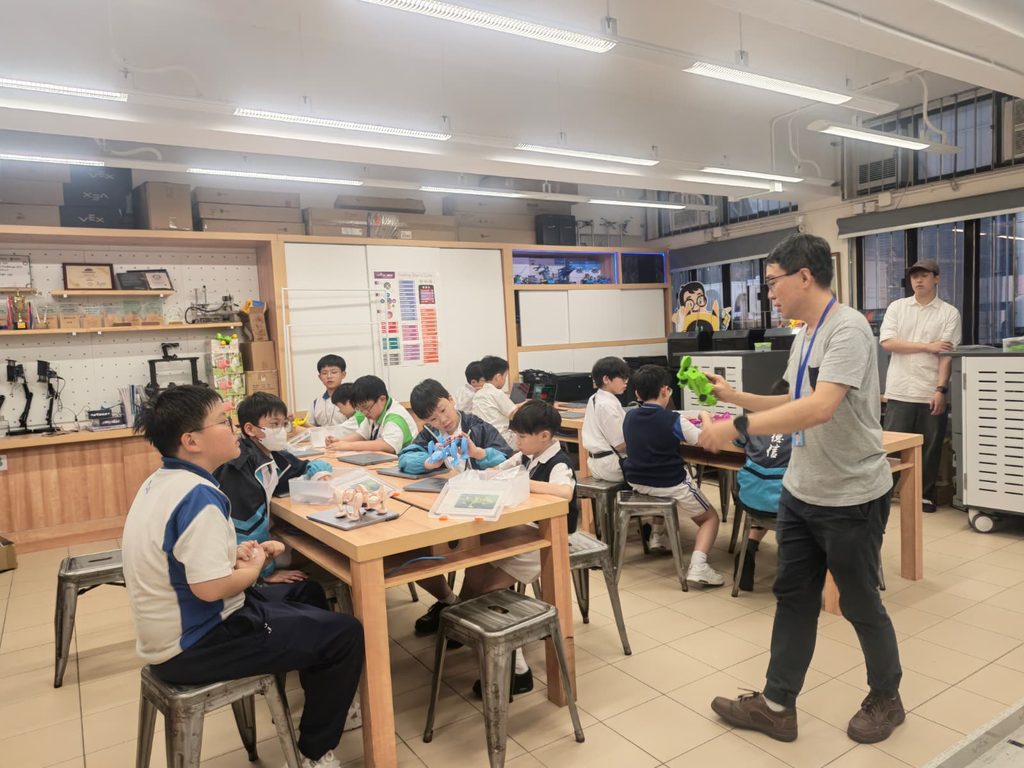 熊天貺 Silas 的世界，常常由一顆小小摩打開始。摩打一轉，孩子眼前的作品便有了動作；程式一跑，原本安靜的機械人開始行路、發聲、閃動。這些在工程師眼中熟悉不過的電子零件，到了 Silas 手上，卻成了小學生理解科技的入口。他相信，STEM 不應只是課本上的概念，也不只是比賽場上的名次，而是讓孩子親手試、親眼看、親自改，從失敗與成功之間學會思考。