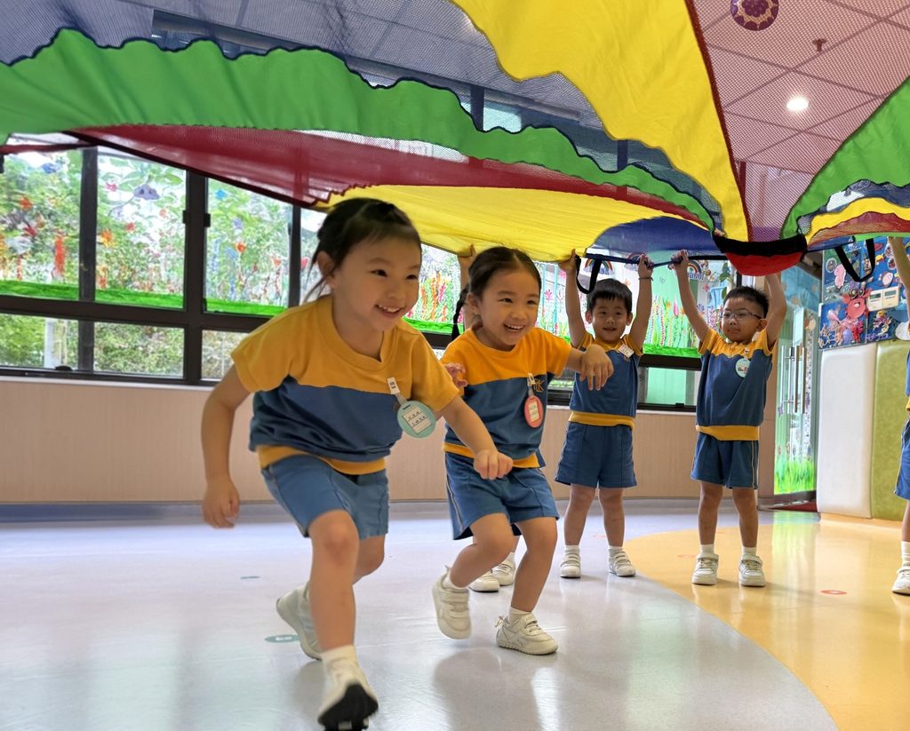 在保良局田家炳幼稚園,梁瑞瑤校長重視的不只是課室裡的孩子,也包括每天接送學生的司機叔叔、在校園不同角落默默照顧孩子的姨姨。這些平日未必站在教育工作的最前線,卻在孩子每天的校園生活中承擔著重要角色。校長一天不上班,學校仍然可以運作;但如果少了司機叔叔或姨姨,孩子日常的安全感和秩序便會受到影響。對梁校長而言,一所學校從來不是只靠校長或老師完成,而是一個彼此承托、環環相扣的群體。這種對人的重視,也成為她教育信念的一部分。教育不是把孩子放進同一個框架,而是讓每一個人都被看見,每一個孩子都有機會被發掘。